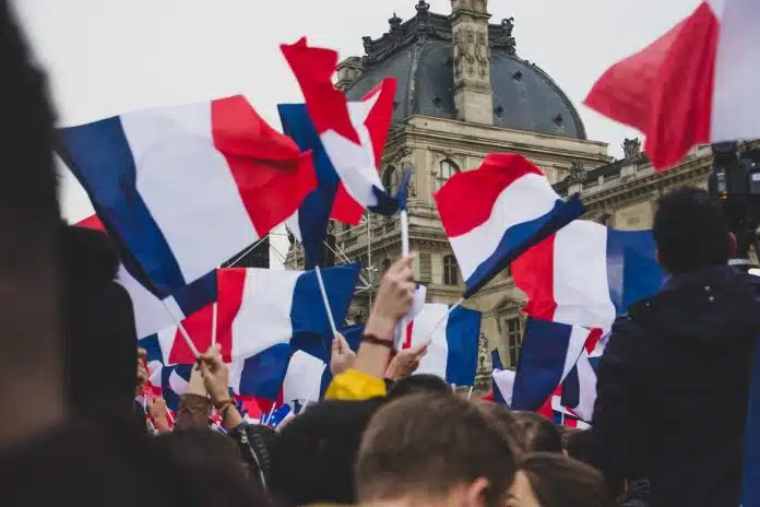 People waving the French flag in front of the Louvre